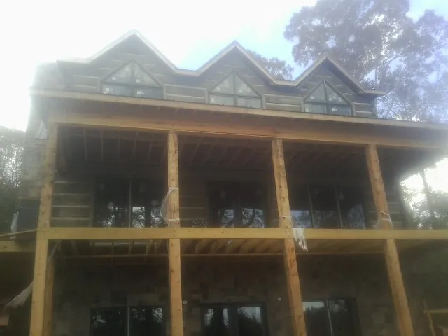 Dormers and porch framing on a large log home under construction — Roof Coating work by our crew in Thornton